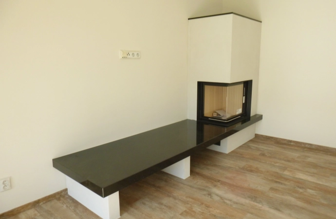 Rohový krb s lavicí